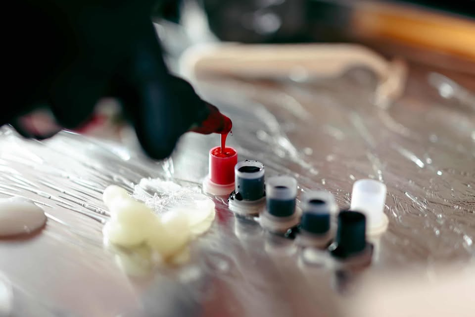 Tattoo ink being poured into small caps